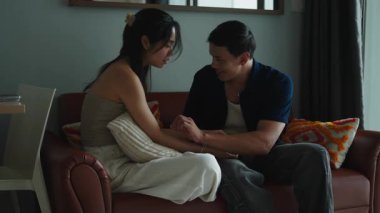 Sevgi dolu bir çift el ele tutuşup oturma odasındaki rahat bir kanepede sohbet ediyorlar.