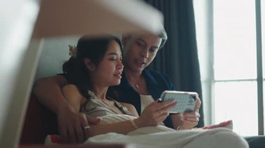 Mutlu çift evdeki kanepede oyun oynuyor.