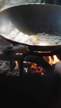 Yakından aşçı eli ateşin közlerini tencerenin altına taşıyor - FullHD Dikey