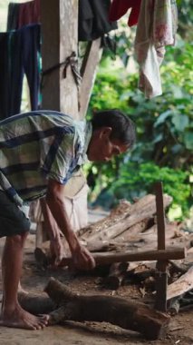 Yalınayak Asyalı lahu Asyalı çiftçi ateş yakmak için odun kesiyor.