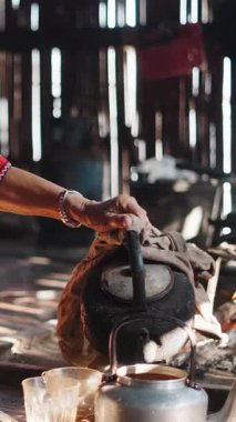 Taylandlı kadın lahu yemek pişirmek için bir çaydanlıktan sıcak su döktü.