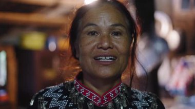 Olgun Taylandlı kadın geleneksel kıyafetlerini giymiş, kır evinde kameraya mutlu bir şekilde gülümsüyor - 4K Yatay