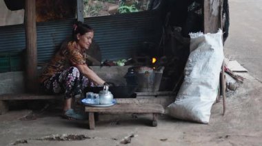 Geleneksel Taylandlı kadın köy mutfağında geleneksel ve ev yapımı bir odun ateşinde çay hazırlıyor - 4K Yatay