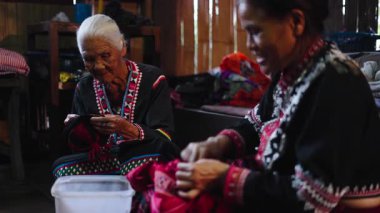 Geleneksel Taylandlı kadınlar geleneksel el yapımı giysileri dikkatlice dikiyorlar - 4K Yatay