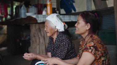 Başında havluyla yaşlı bir kadın kızıyla sohbet ediyor ve kötü bir çevrede hikâyelerini paylaşıyor - 4K Yatay