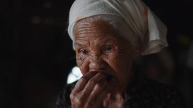 Kafasında kirli bir havluyla Tayland 'da huzur içinde taze çileklerin tadını çıkaran bir büyükannenin portresi - 4K Yatay