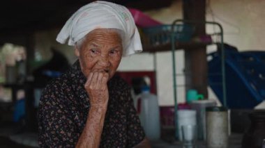 Asyalı son sınıf öğrencisi, az dişli, geleneksel bir ortamda taze kırmızı meyve tadıyor - 4K Yatay