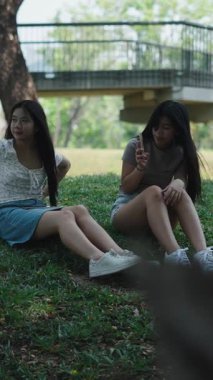 İki genç parkta fotoğraf çekerken eğleniyor.