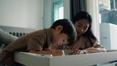 Aile paylaşımı öğrenme anı, eğitim kitabı okumada çocuğa rehberlik eden ebeveynler.