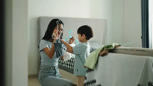 Aile, rahat yatak odası ortamında kıyafet seçiminden keyif alıyor.