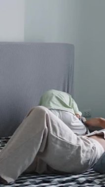 Sevgi dolu anne, sevgi dolu oğul, yumuşak yatak örtüsünde şefkatli anlar paylaşıyor.