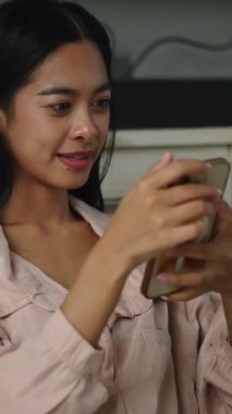 Neşeli kadın akıllı telefondan zevk alıyor, gülümsüyor.