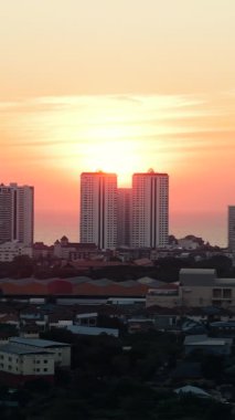 Şehir gün batımında gökyüzü rengarenk ve arka planda okyanus - FullHD dikey