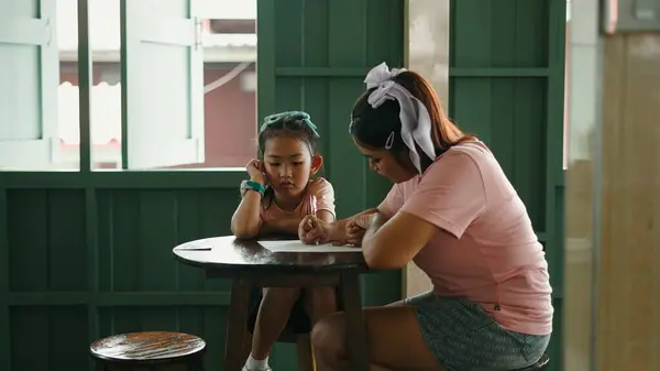 Kadın ve çocuk rahat bir odada birlikte çalışıyorlar.