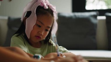 Kafasında yay olan Asyalı bir kız öğretmeninin yardımıyla yazmayı öğreniyor - 4K Yatay