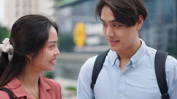 İki genç profesyonel modern şehir ortamında dostça bir sohbetin tadını çıkarıyorlar.