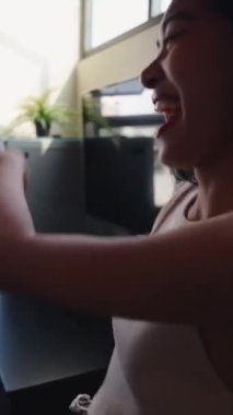 Şapkalı ve gözlüklü Asyalı çift mutfakta dans ediyor ve eğleniyorlar.