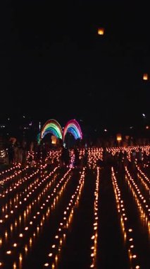 Bangkok Tayland 'da yere dizilmiş binlerce mum üzerinde kağıt fenerler göğe yükseliyor.