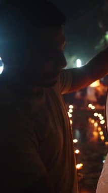 Genç Latin adam fener yangınının yardımıyla gökyüzüne yükselmek için büyük kağıt fenerler hazırlıyor.