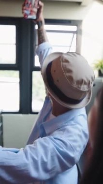 Genç Asyalı çift şapka ve gözlük takıp dans ediyor ve akıllı bir telefonla kendilerini kaydediyorlar.