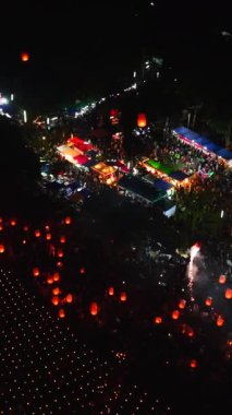 Bangkok Tayland 'daki fener festivali gecesinde binlerce mum yakan insansız hava aracı FullHD Dikey