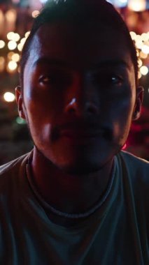 Genç Latin adam fener festivalinde yüzlerce mum yakarak kameraya bakıyordu FullHD Dikey