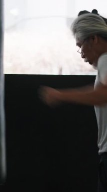 Dövüş Sanatlarında Güç ve Beceriklilik Gösteren Yumruk Torbasıyla Kıdemli Adam Eğitimi