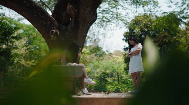 Bereketli tropikal yeşilliğin ortasında profesyonel bir model yakalayan kadın fotoğrafçı.