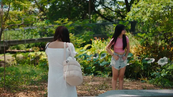 Profesyonel fotoğrafçı, botanik bahçesinin yemyeşil, güneş ışığının ön plana çıktığı yerde manken portresi çekiyor.