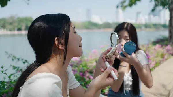 Dışarıda takılırken makyaj yapan arkadaşlar göl kenarına gider.