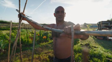 Yetişkin çiftçiler, sebze bahçesinde bambu bitkileri inşa ederek, artan ürün büyümesini destekliyor.