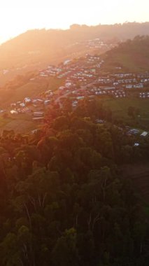 Bir dağ köyünü aydınlatan gün doğumu ve ekili tarlaları - FullHD Dikey