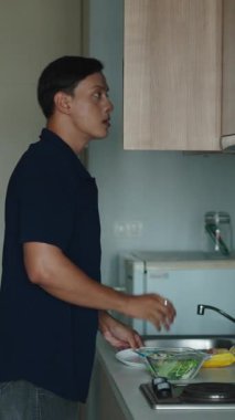 Erkek aşçı, besleyici bir salata hazırlarken mutfak yerini düzenliyor.