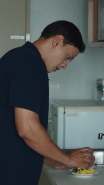 Asyalı Adam Fast Food 'u hazırlıyor ve onları kolayca mikrodalgada ısıtıyor.