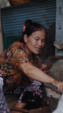 İki yaşlı Asyalı kadın, mütevazı bir kulübede, FullHD Dikey Ahşap bir ateşte yemek hazırlıyorlar.