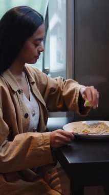 Besleyici bir yemekten önce bir kase pirinci taze limon damlasıyla süsleyen kadın - FullHD Dikey