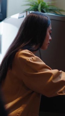 Genç Asyalı kadın mutfak masasında sağlıklı vejetaryen salatasının tadını çıkarıyor.