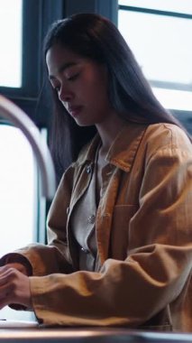 Genç Asyalı kadın, FullHD dikey bir mutfakta ahşap bir kesme tahtasıyla taze kireç kesiyor.