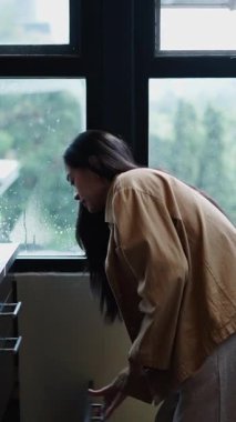 Taze yemek hazırlayan genç bir kadın buzdolabını açar ve pencereden kesilmiş karpuzu çıkarır.