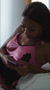 Uzun tırnaklı trans kadın yatakta akıllı telefon kullanıyor - FullHD dikey