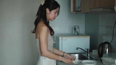 Asyalı kadın modern ve rahat mutfakta kahvaltı hazırlıyor.