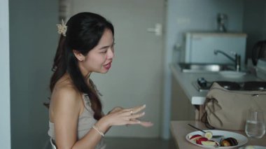 Kadın sabah kahvesinden zevk alıyor, mutfak penceresinin yanında rastgele sinyal veriyor.