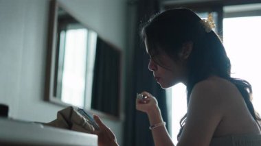 Kadın kahvesini yudumluyor, sabah yemeğinde dijital cihaz kayıyor.