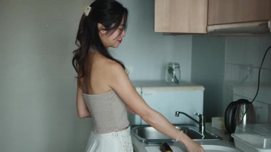 Genç bir kadın taze malzemeler doğradı, şık mutfak alanında besleyici bir sabah yemeği yaptı.