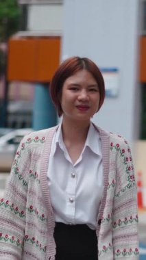 İki Asyalı kız öğrenci yan yana yürüyor gülümsüyor ve kameraya bakıyor - FullHD Dikey