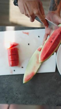 Usta aşçı, karpuzu, el değmemiş kesim yüzeyinde üçgen parçalara ayırıyor.