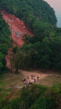 Khao Phang perspektifinde toplanan turistler, Chumphon, Tayland 'daki dağlık araziyi aydınlatan altın güneş ışığını izliyorlar.