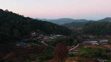 Hava manzarası, altın gün batımında mon jam köyünü gözler önüne seriyor, dağ manzarası, kuzey Tayland kırsalını aydınlatıyor.
