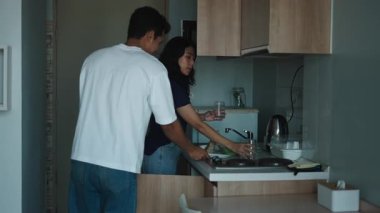 Mutlu çift modern mutfaklarında birlikte yemek hazırlıyor - 4K Yatay