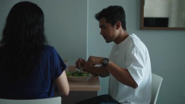 Modern dairede birlikte salata yiyen mutlu çift - 4K Yatay